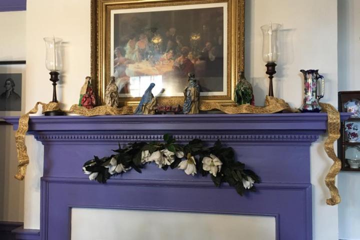 a room filled with furniture and vase of flowers next to a fireplace