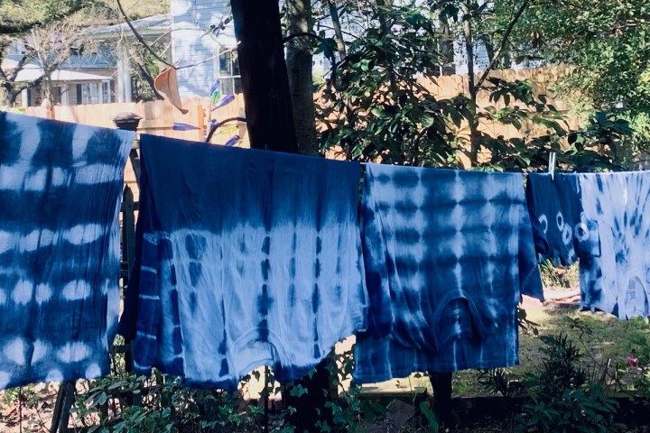 a bed with a blue seat sitting in a forest