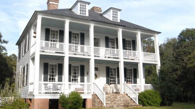 a large brick building with grass in front of a house
