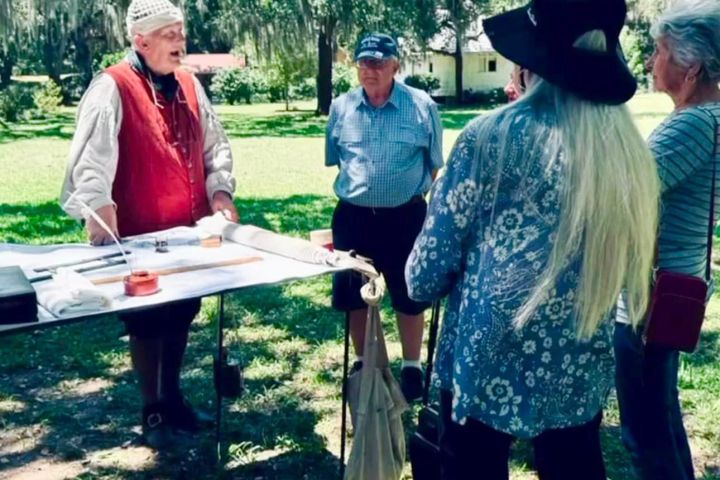 a group of people standing on top of a picnic table