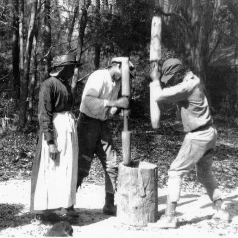 Hulling Rice a group of people standing next to a forest